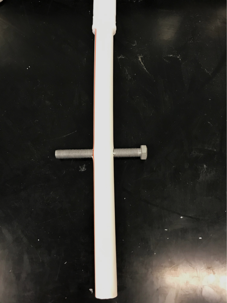 Arora & London, Figure 3: Photograph of PVC pipe post-drilling with bolt threaded through hole.
